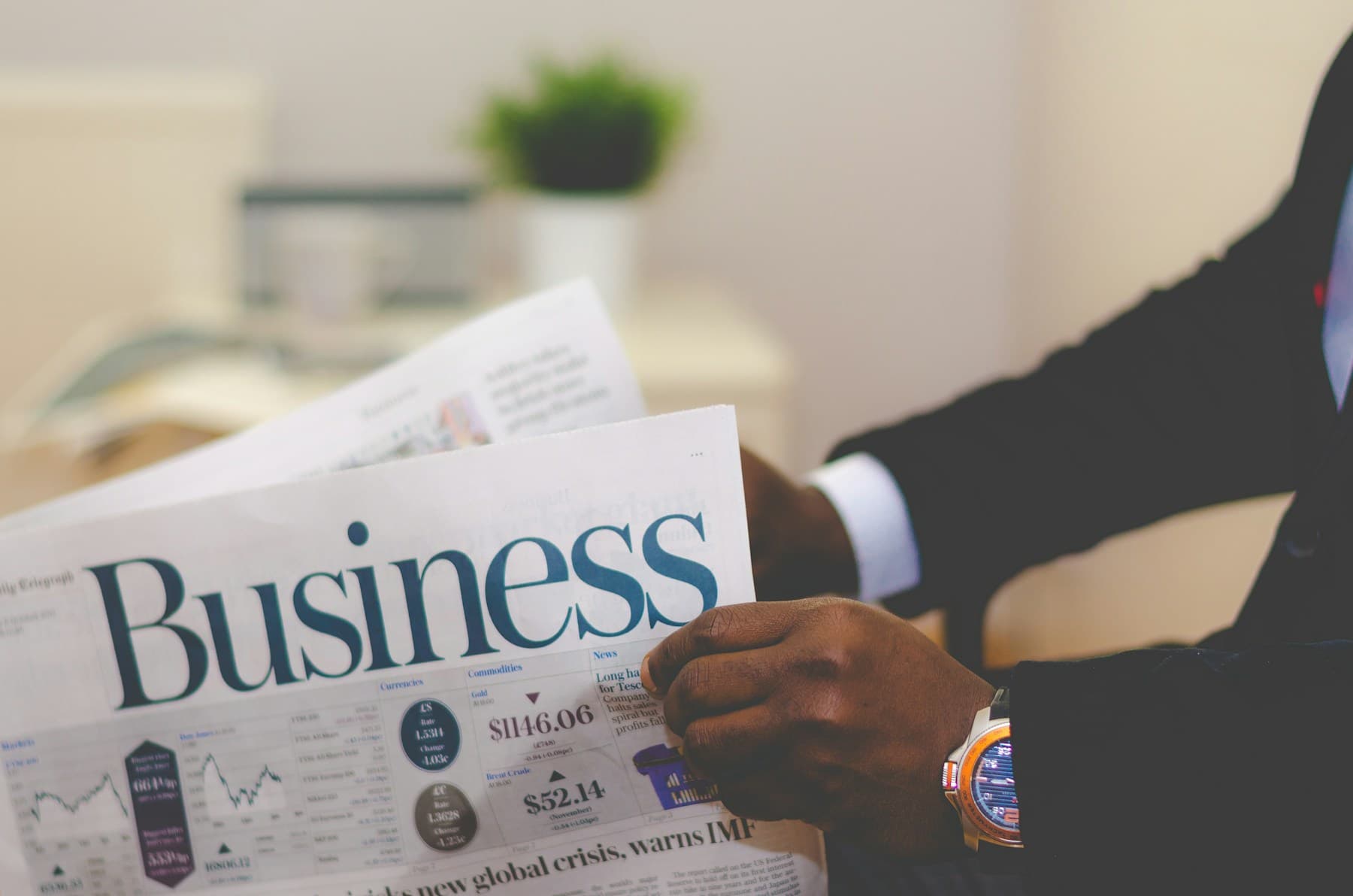 A suited professional reading the business news